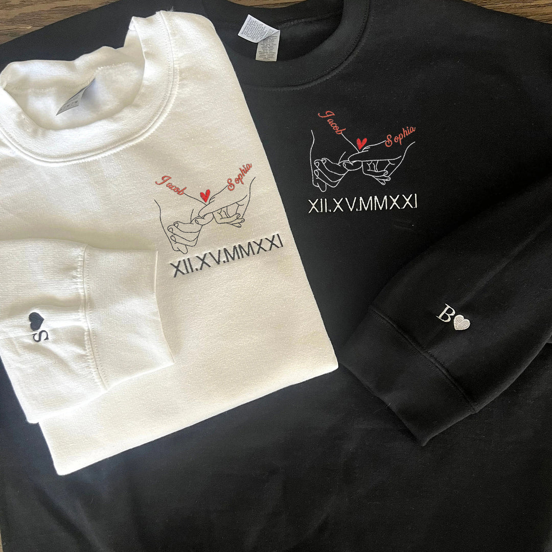 Sweat-shirts brodés en chiffres romains avec les noms des couples, main dans la main.