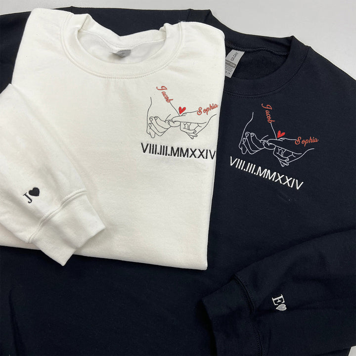 Sweat-shirts brodés en chiffres romains avec les noms des couples, main dans la main.